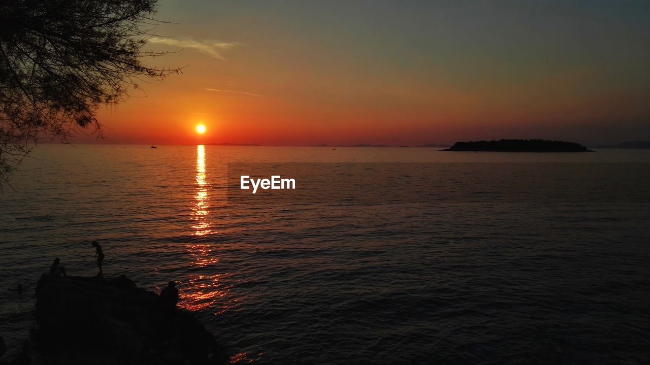 Scenic view of sea against orange sky