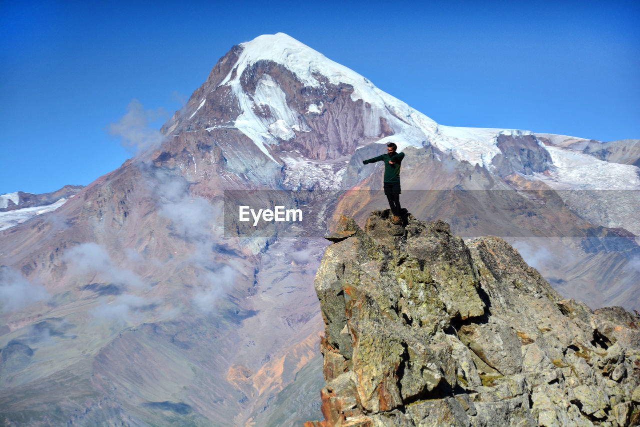 The young boy is dancing with mountain kazbegi