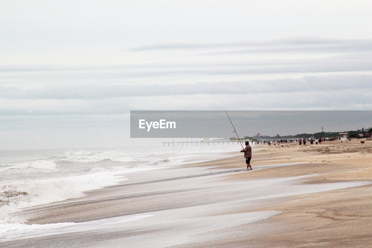 Fishermen on the beach, details of bait and lines of fishing rods.man on beach against sky