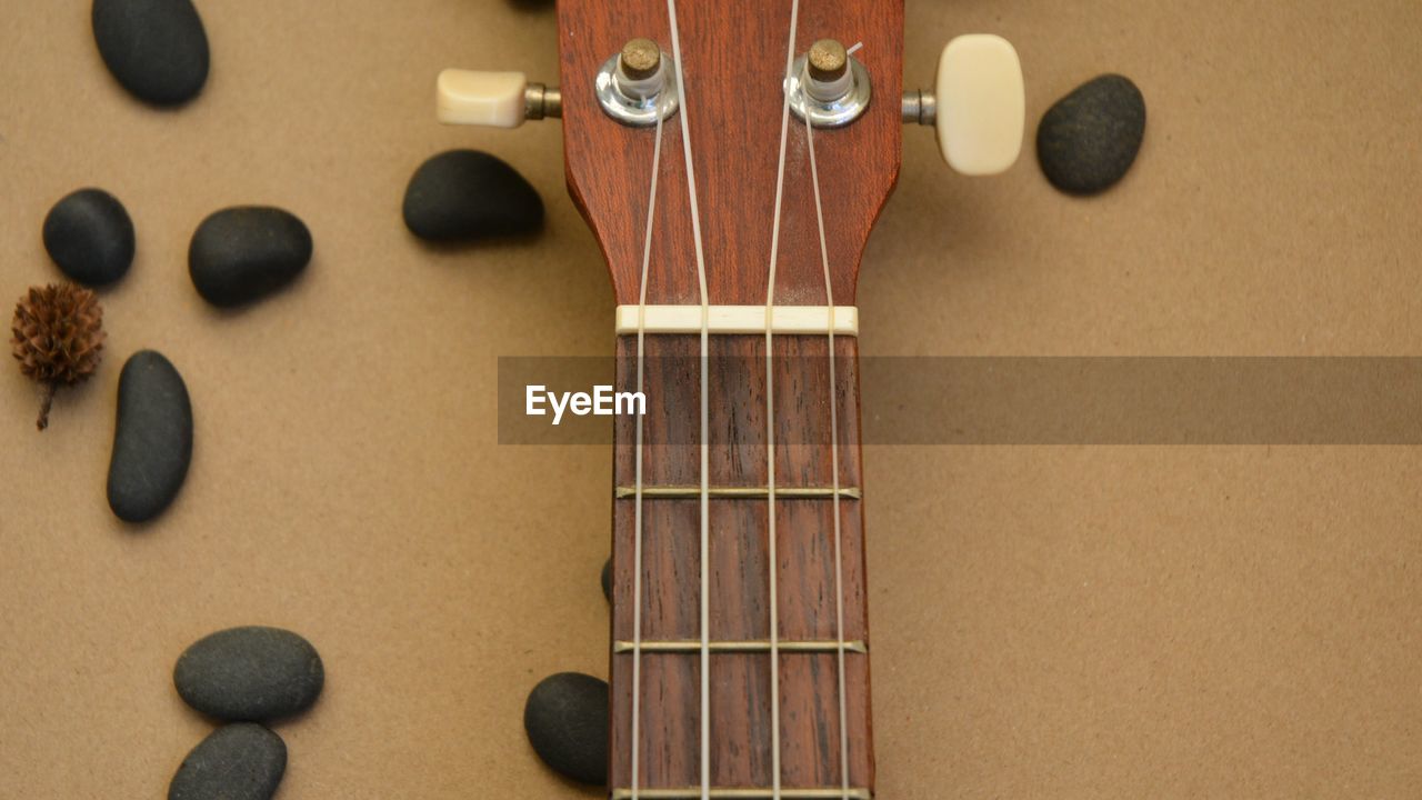 Close-up of guitar and pebbles on table