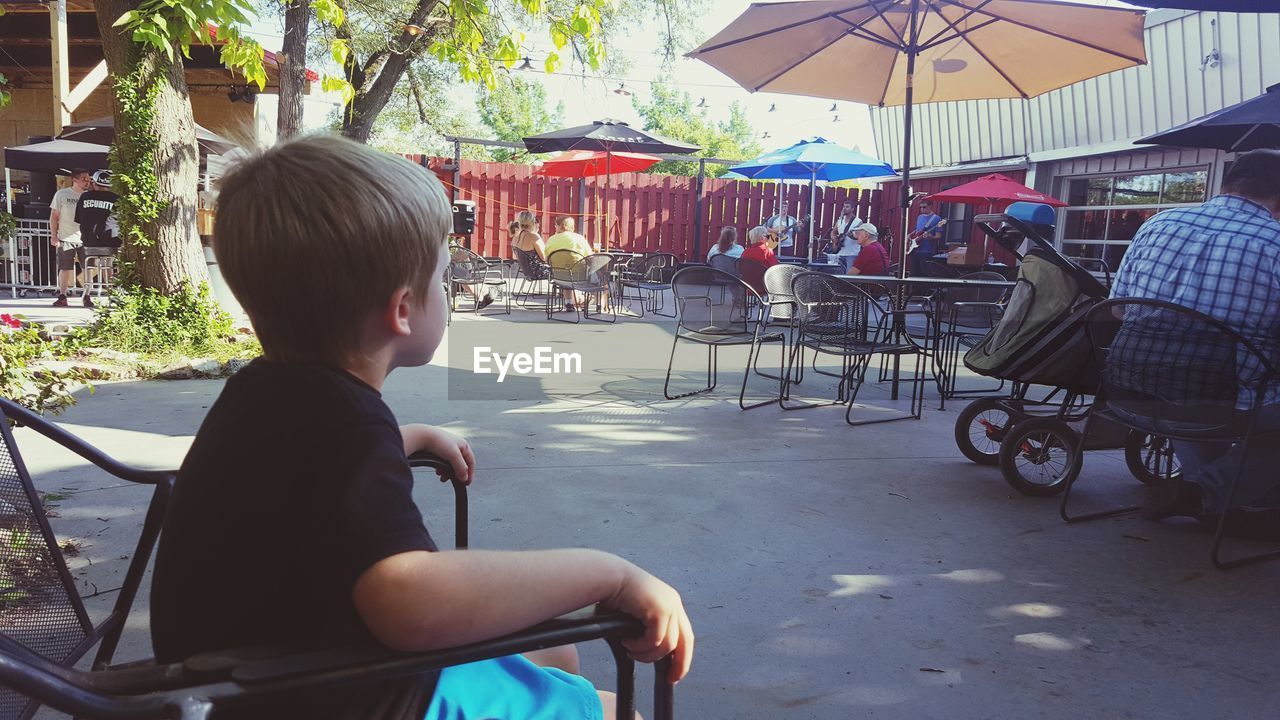 SIDE VIEW OF BOY SITTING AT TABLE