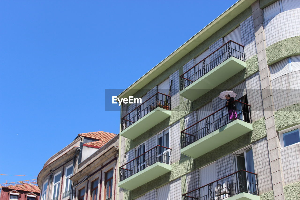 LOW ANGLE VIEW OF BUILDINGS AGAINST BLUE SKY