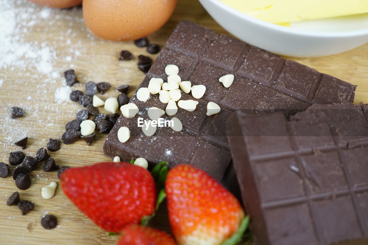 Butter and chocolate bar and chocolate chips on a wooden background. 