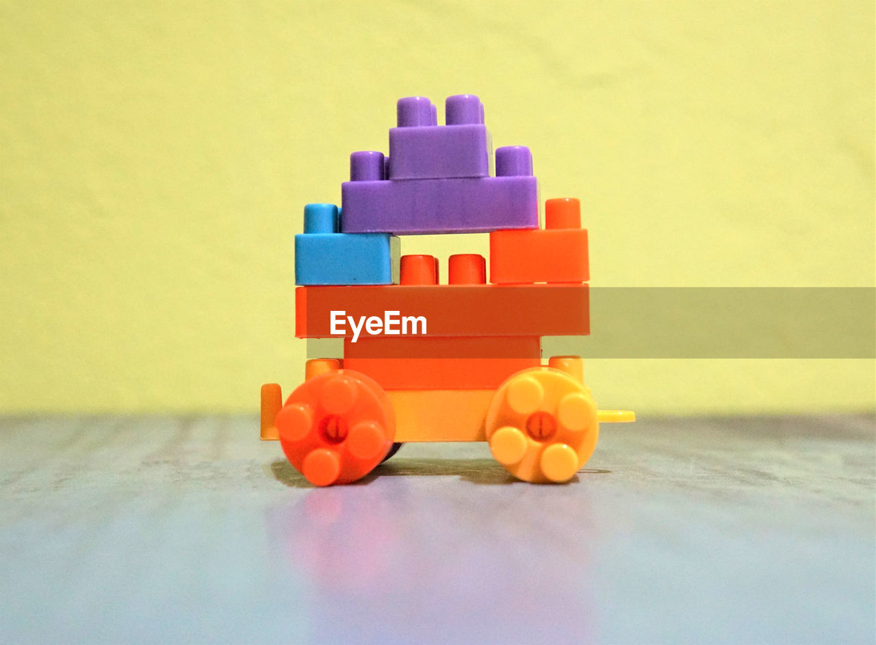 CLOSE-UP OF TOYS ON TABLE AGAINST WALL