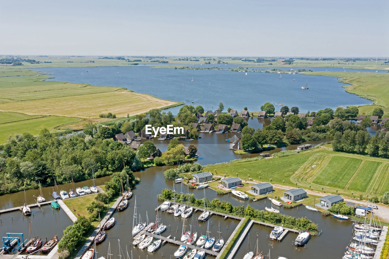 high angle view of cityscape by sea against clear sky