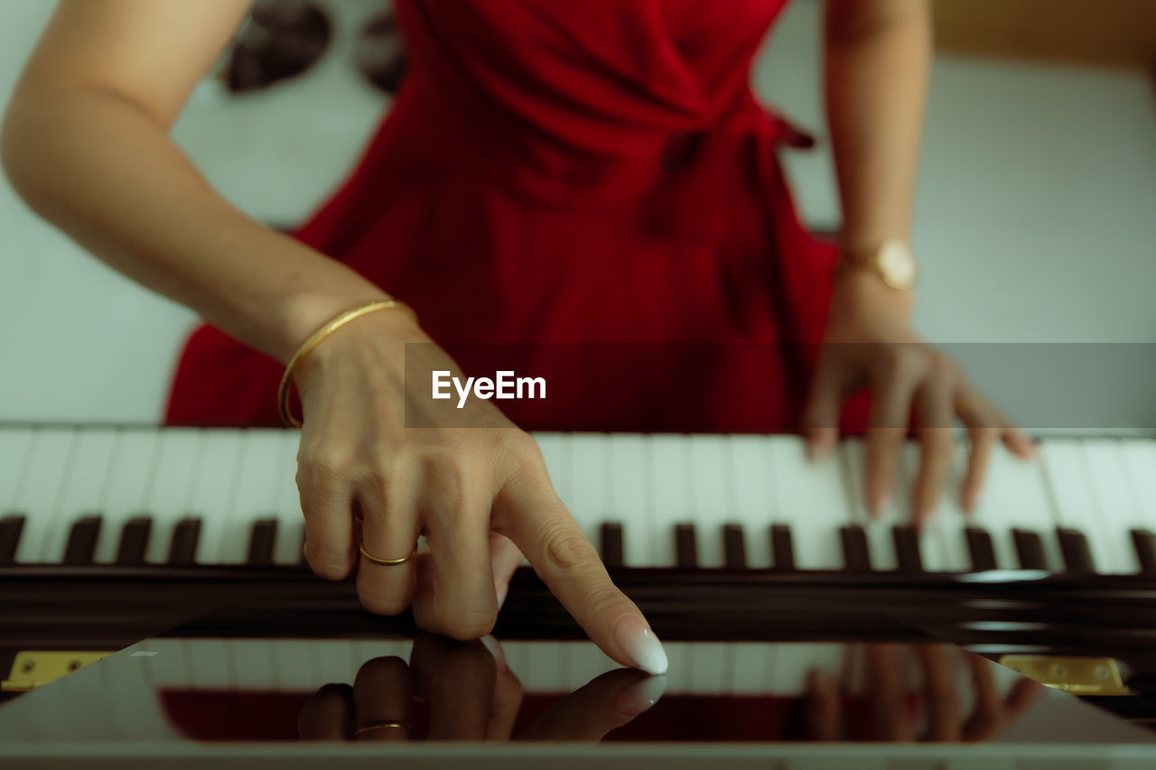 MIDSECTION OF MAN PLAYING PIANO IN NIGHTCLUB