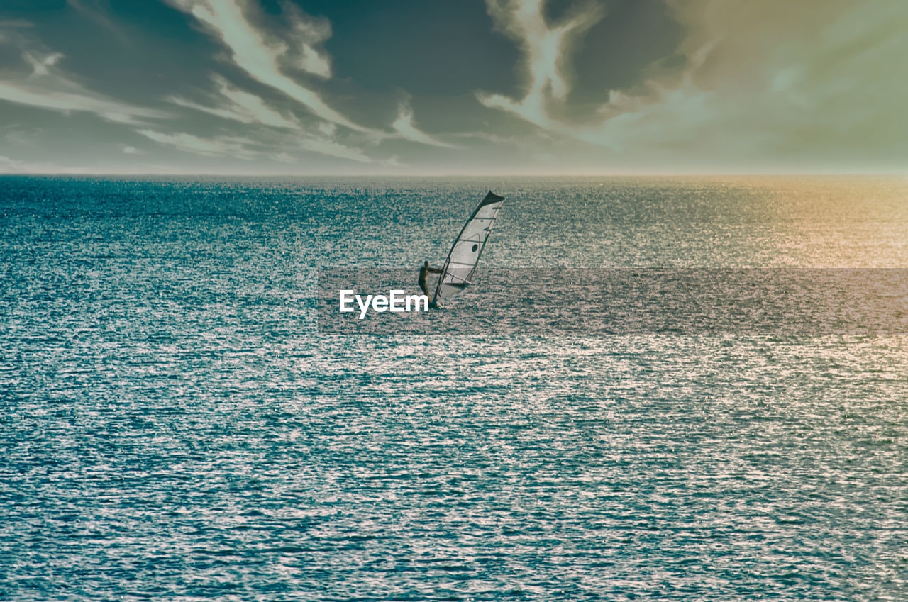 Windsurfer at sea in sunset. the black sea. view from afar. the sky is frowning.