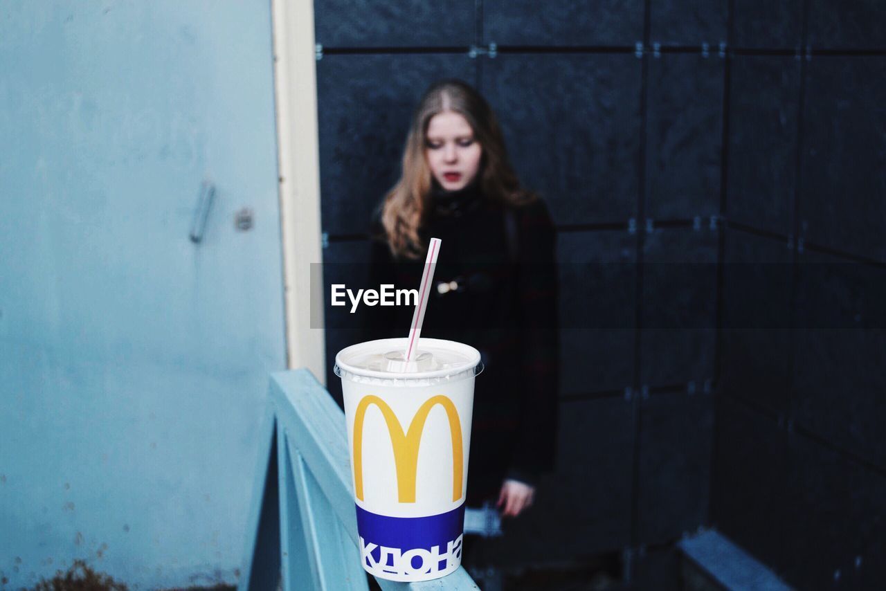 CLOSE-UP OF YOUNG WOMAN WITH COFFEE