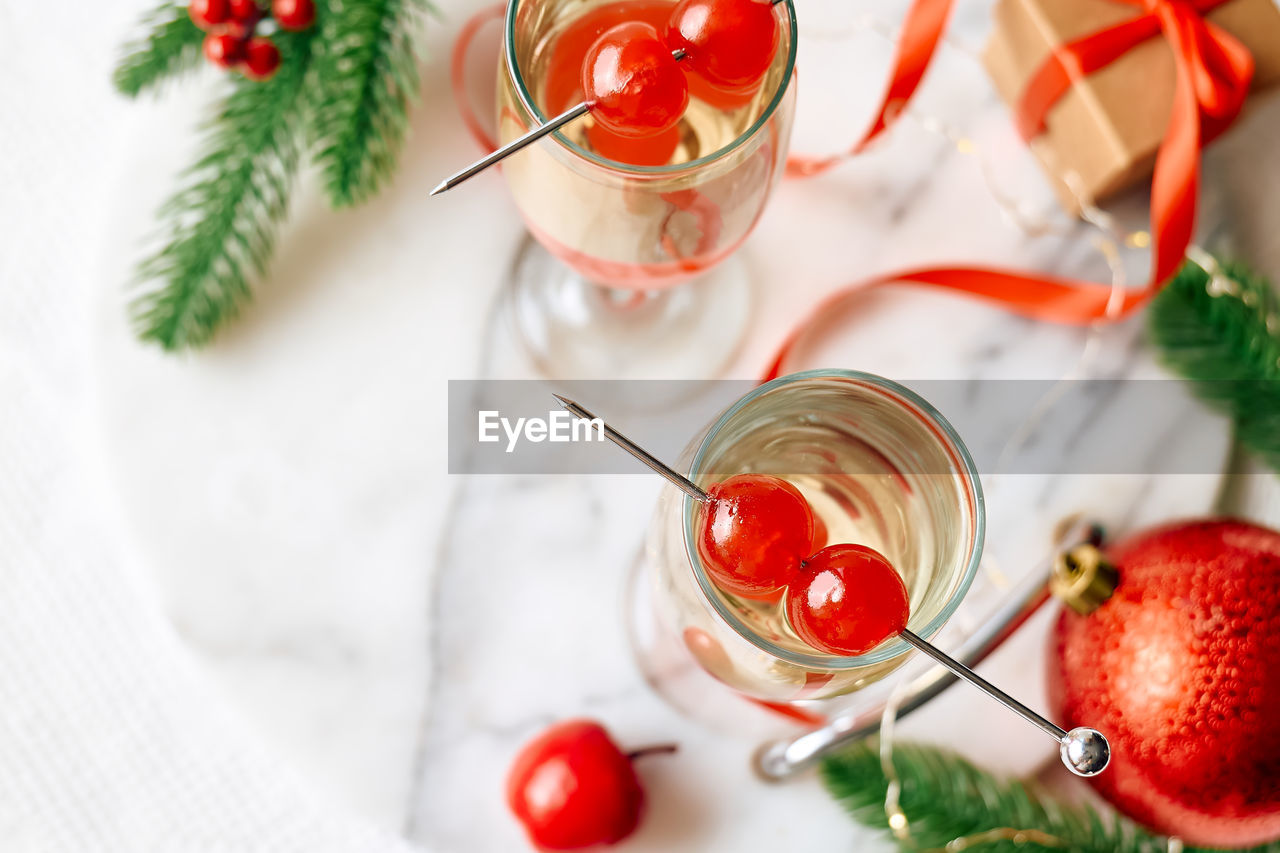 Christmas cocktail with sparkling wine, rosemary and cherry. winter holidays champagne drink.