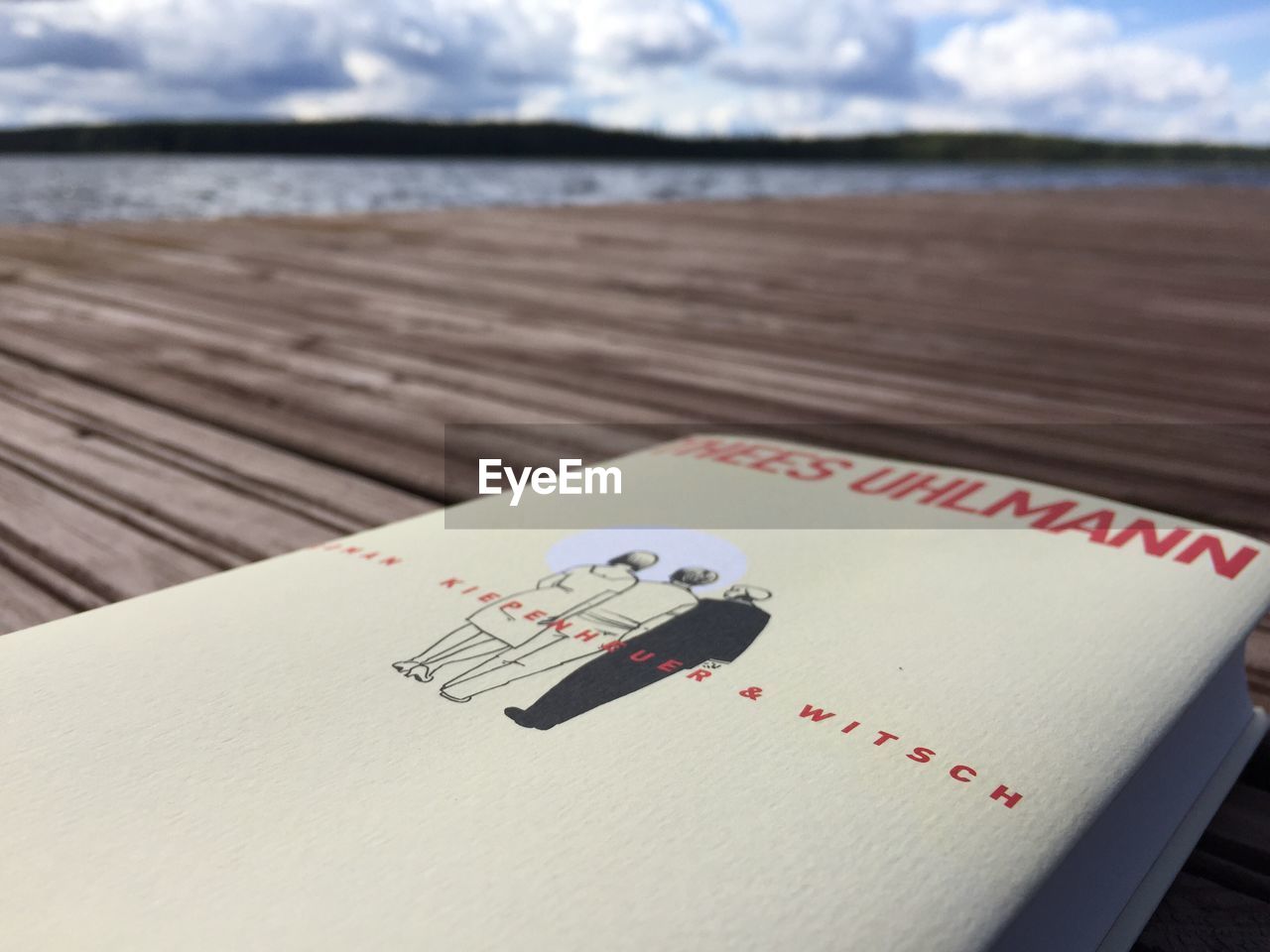 CLOSE-UP OF OPEN BOOK ON WOODEN TABLE