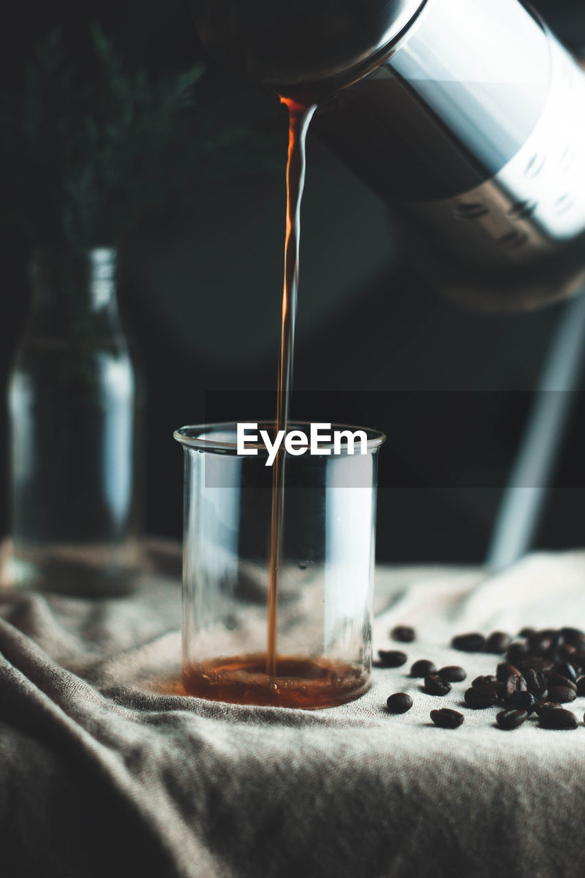 CLOSE-UP OF COFFEE CUP IN GLASS