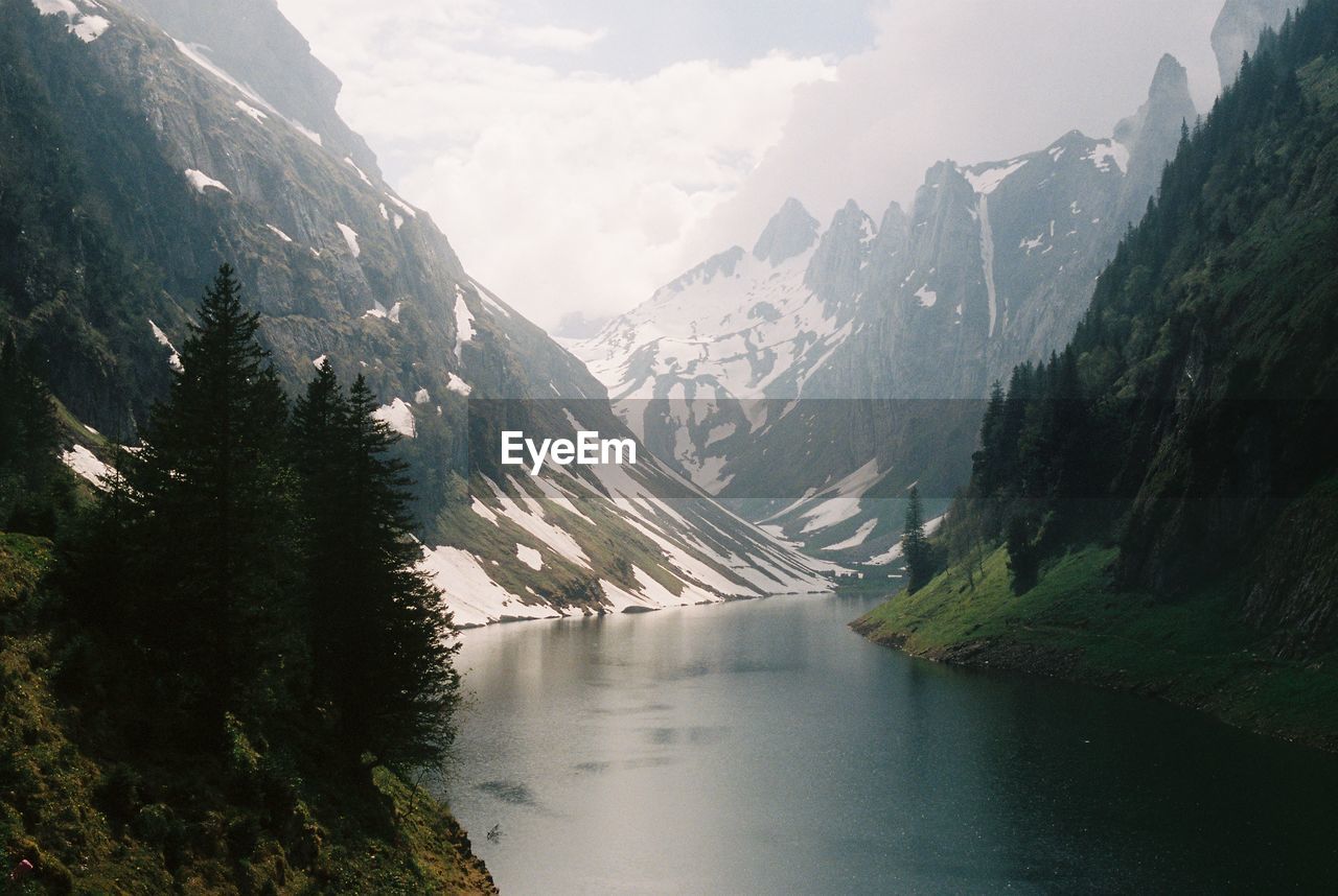 Scenic view of lake amidst mountains against sky