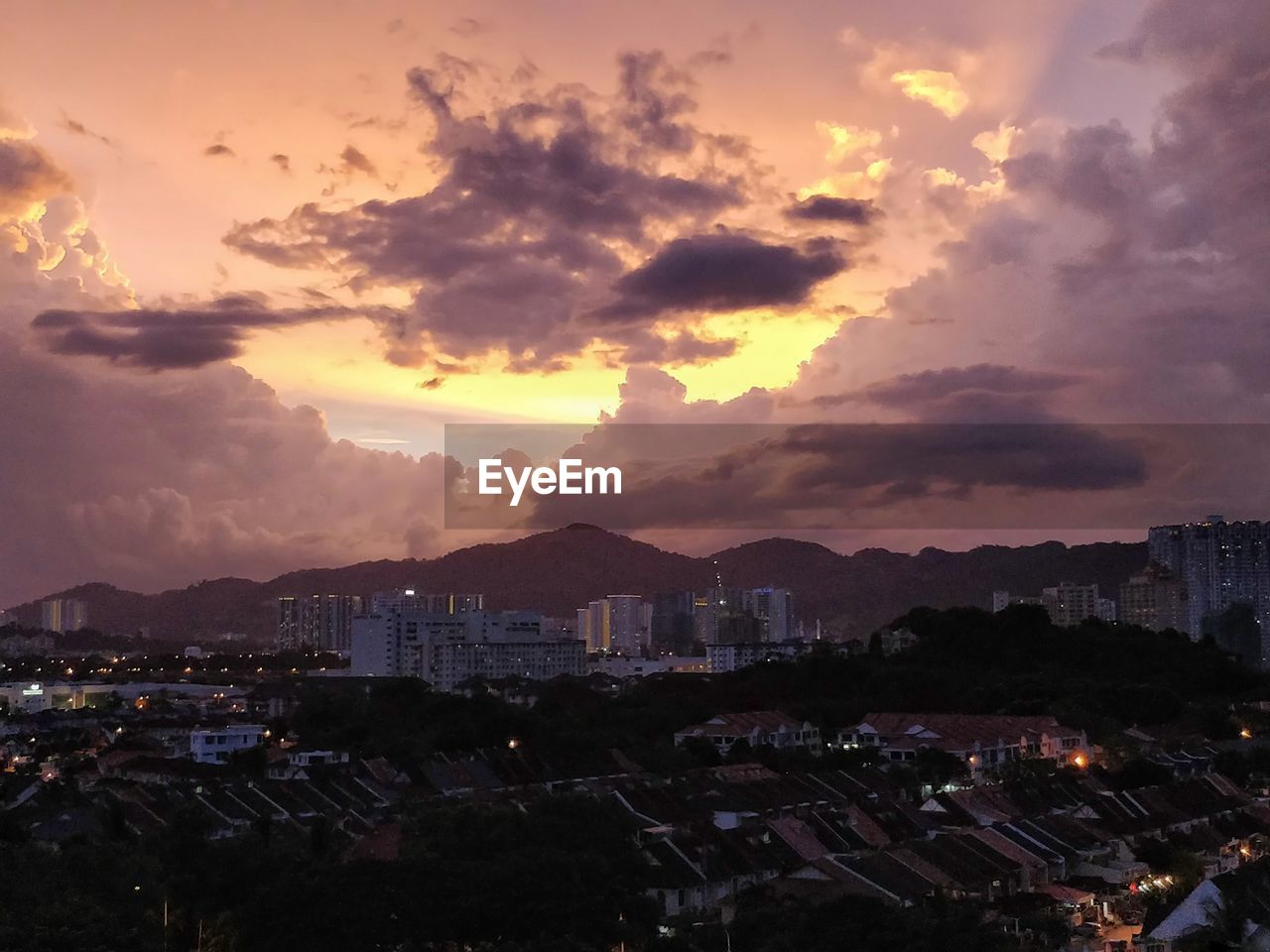 VIEW OF TOWN AGAINST SKY AT SUNSET