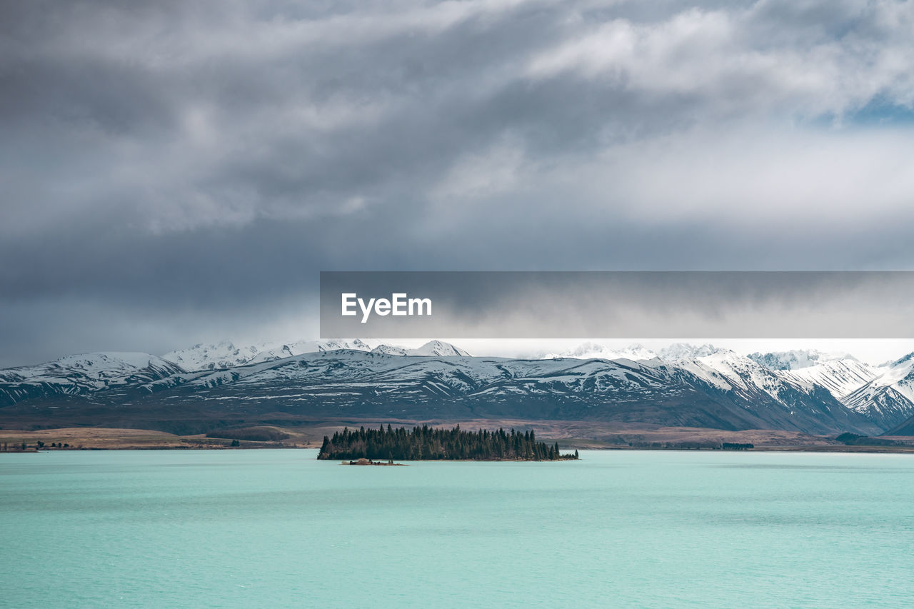 A scenic landscape of new zealand southern alps and lake tekapo with blue sky and clouds.