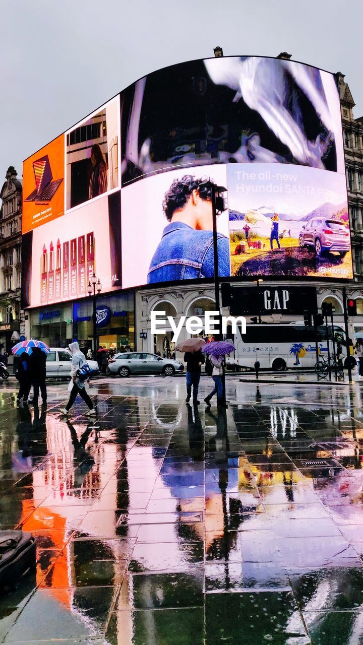 DIGITAL COMPOSITE IMAGE OF PEOPLE WITH UMBRELLA IN RAIN