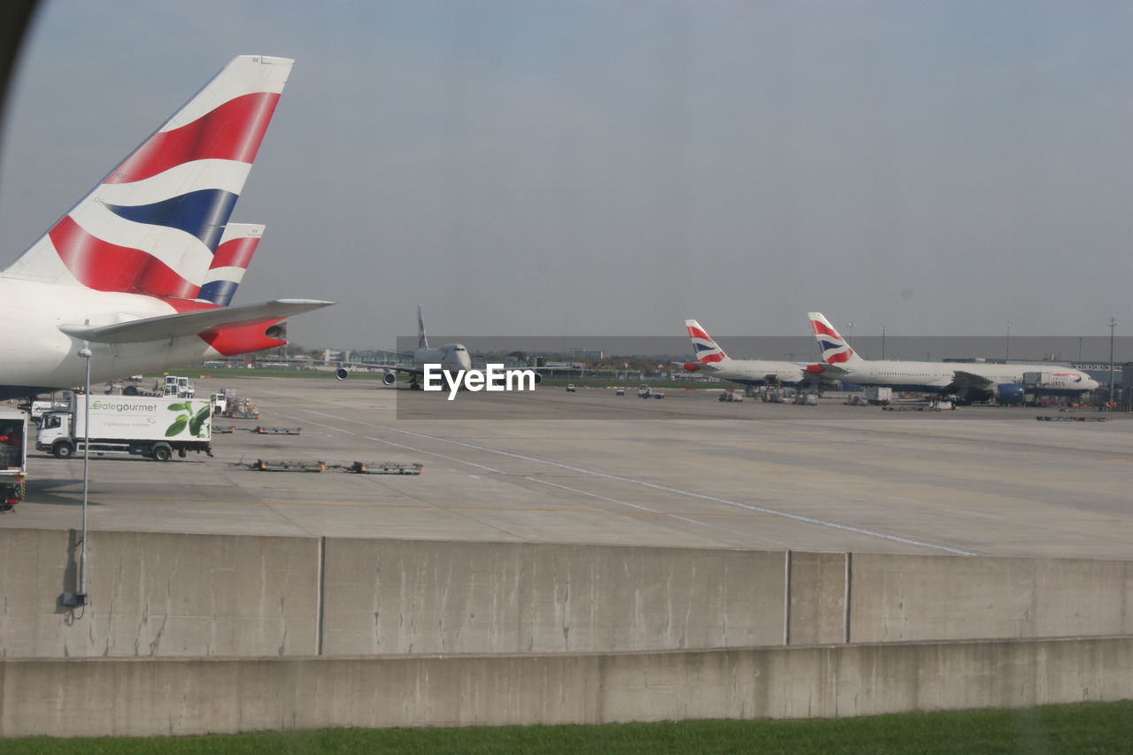 AIRPLANE FLYING OVER AIRPORT RUNWAY