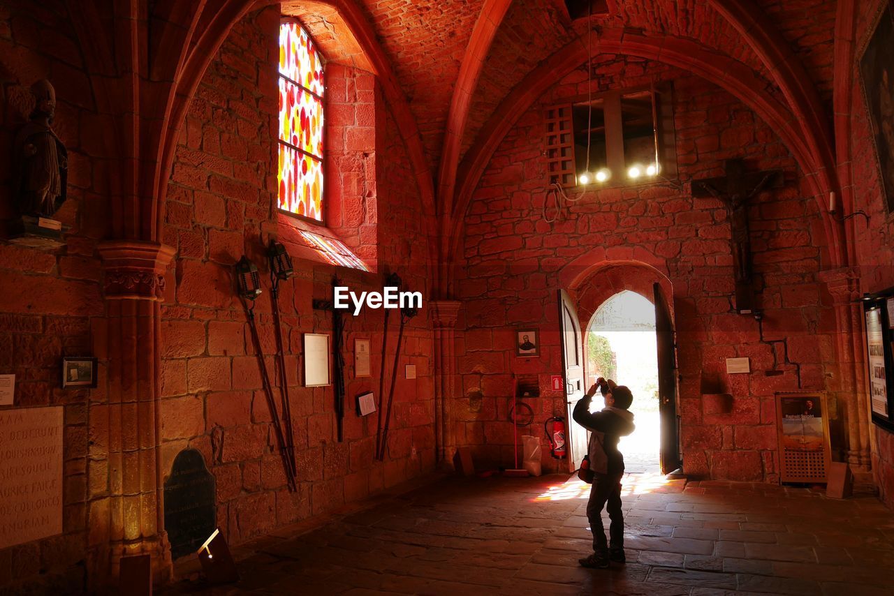 WOMAN WALKING IN CORRIDOR OF BUILDING