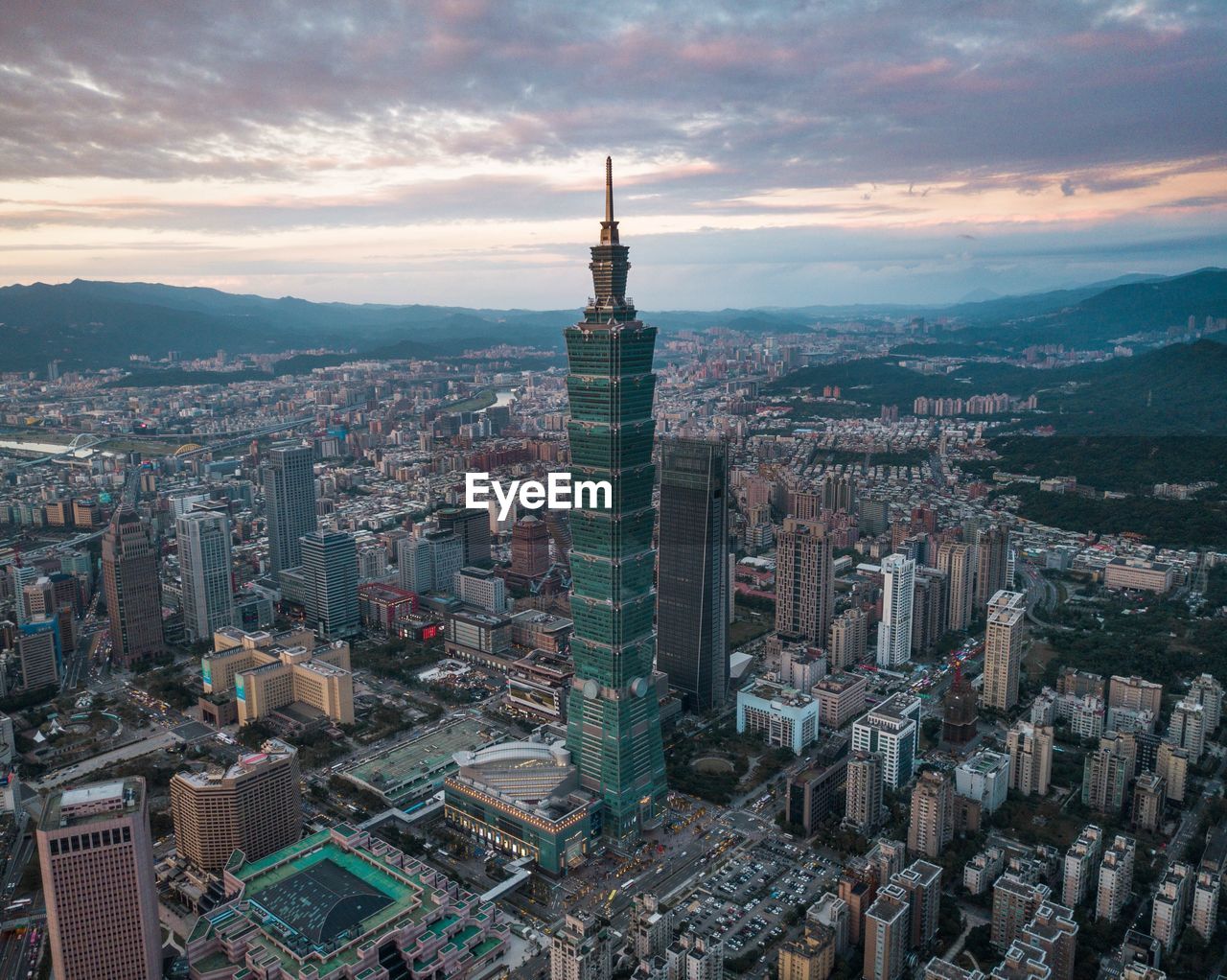 High angle view of city buildings against cloudy sky