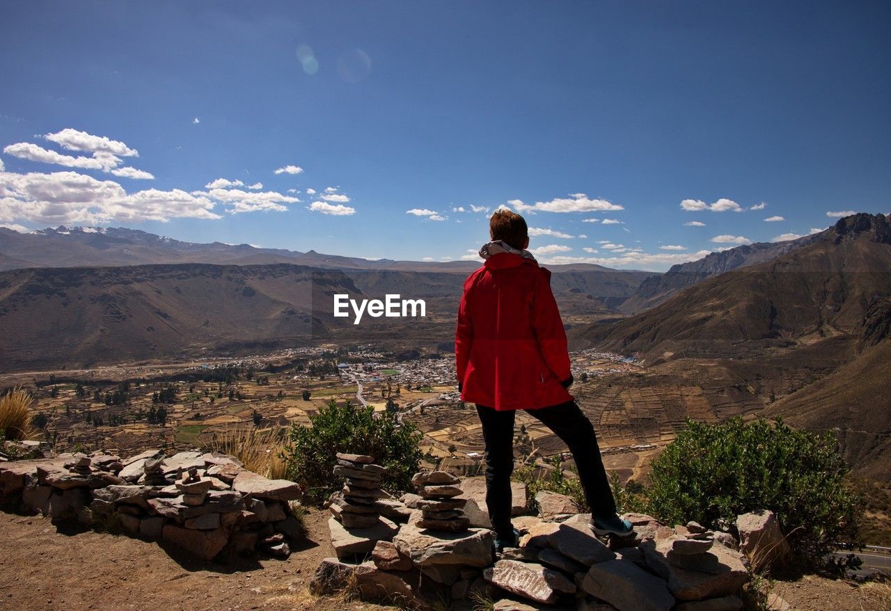 Rear view of senior woman standing above the valley of chivay, peru