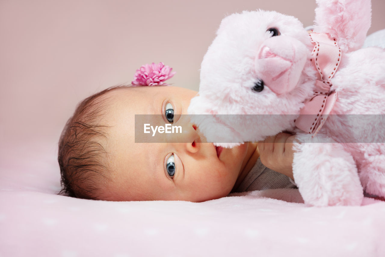 portrait of cute baby girl lying on bed at home