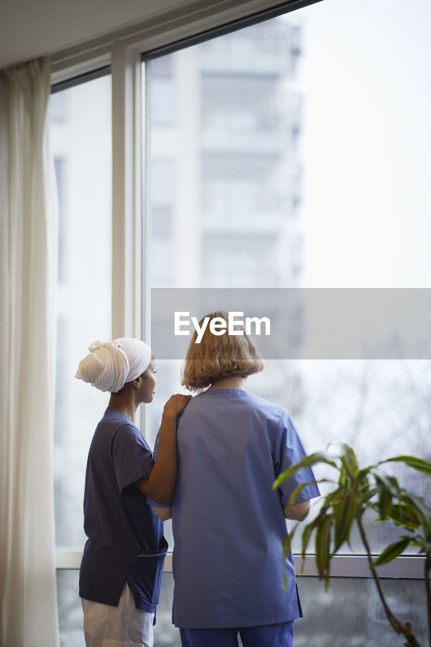 Female doctors standing and talking at hospital corridor