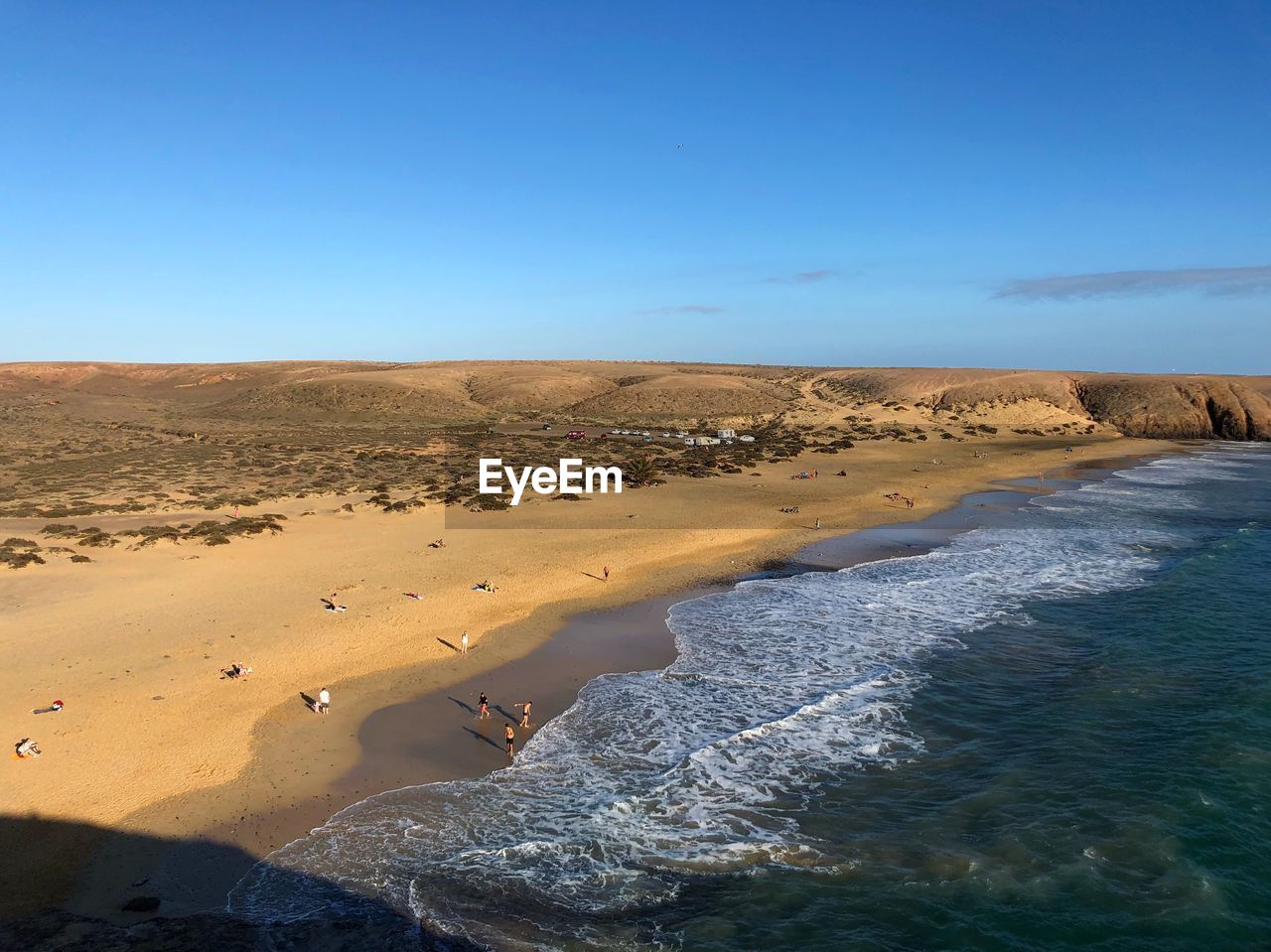 Scenic view of sand dunes against clear blue sky