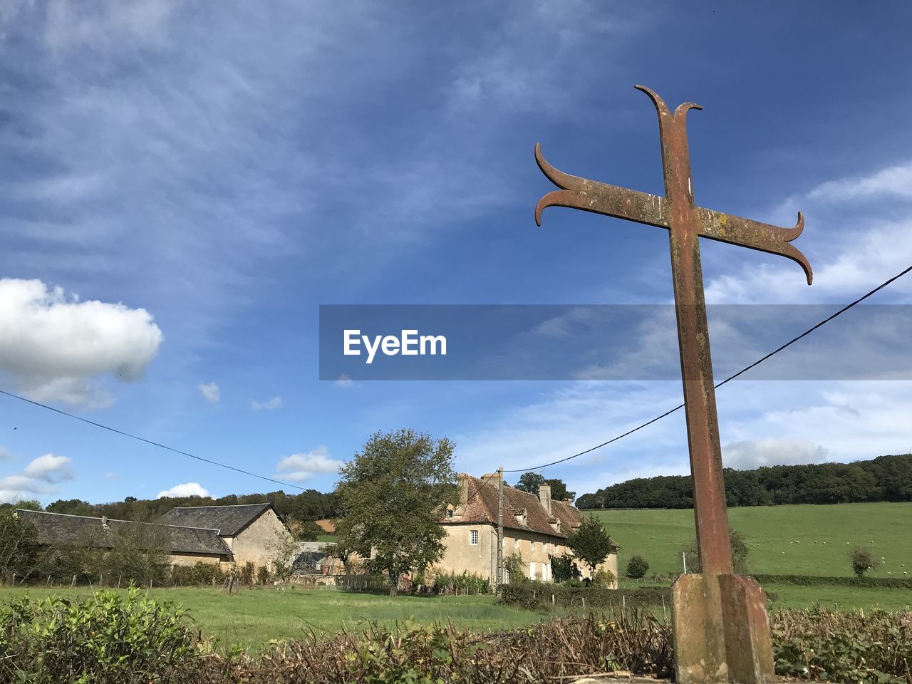 CROSS ON FIELD AGAINST BUILDINGS