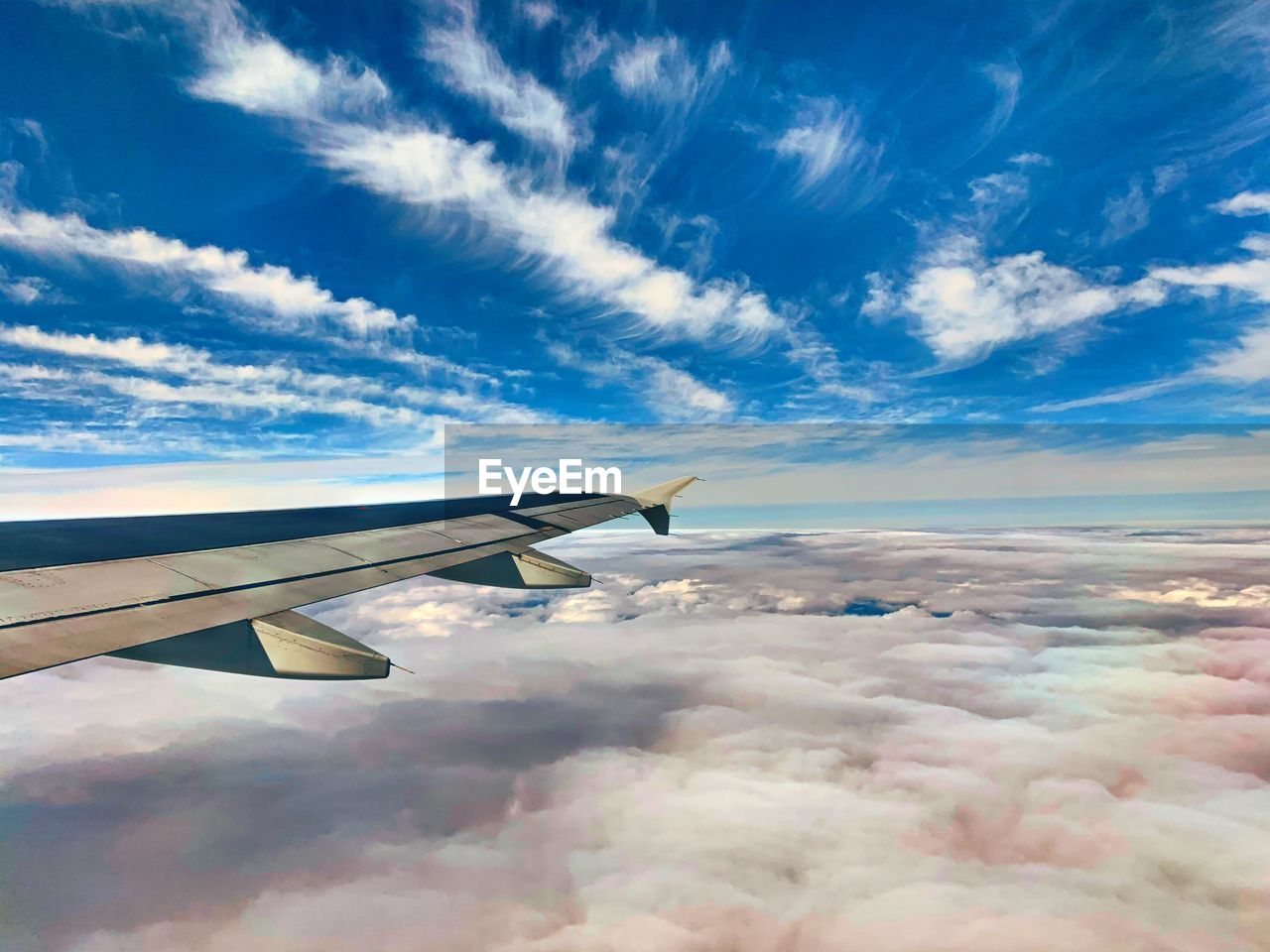 AIRPLANE FLYING OVER BLUE SKY