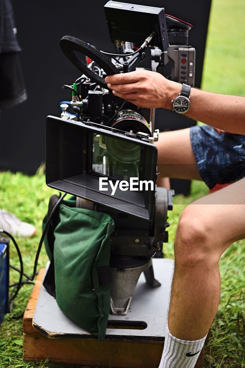 MIDSECTION OF MAN PHOTOGRAPHING WITH CAMERA