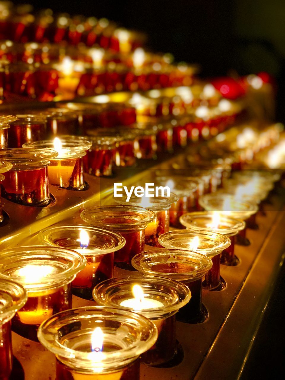 Close-up of illuminated candles in temple