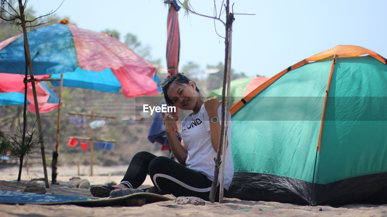 FULL LENGTH OF MAN SITTING AT TENT