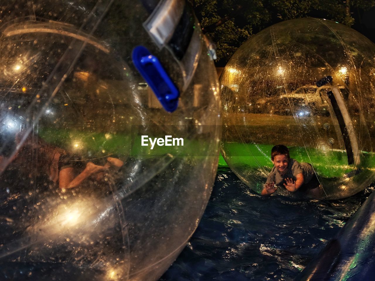 Boy in zorb ball floating on water at gage county fair during night