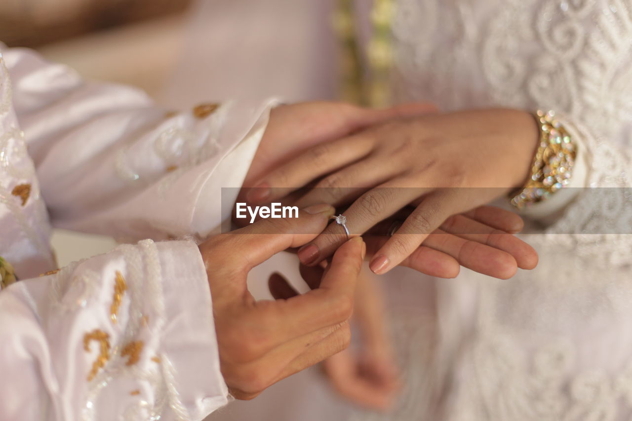 Midsection of bride holding wedding dress