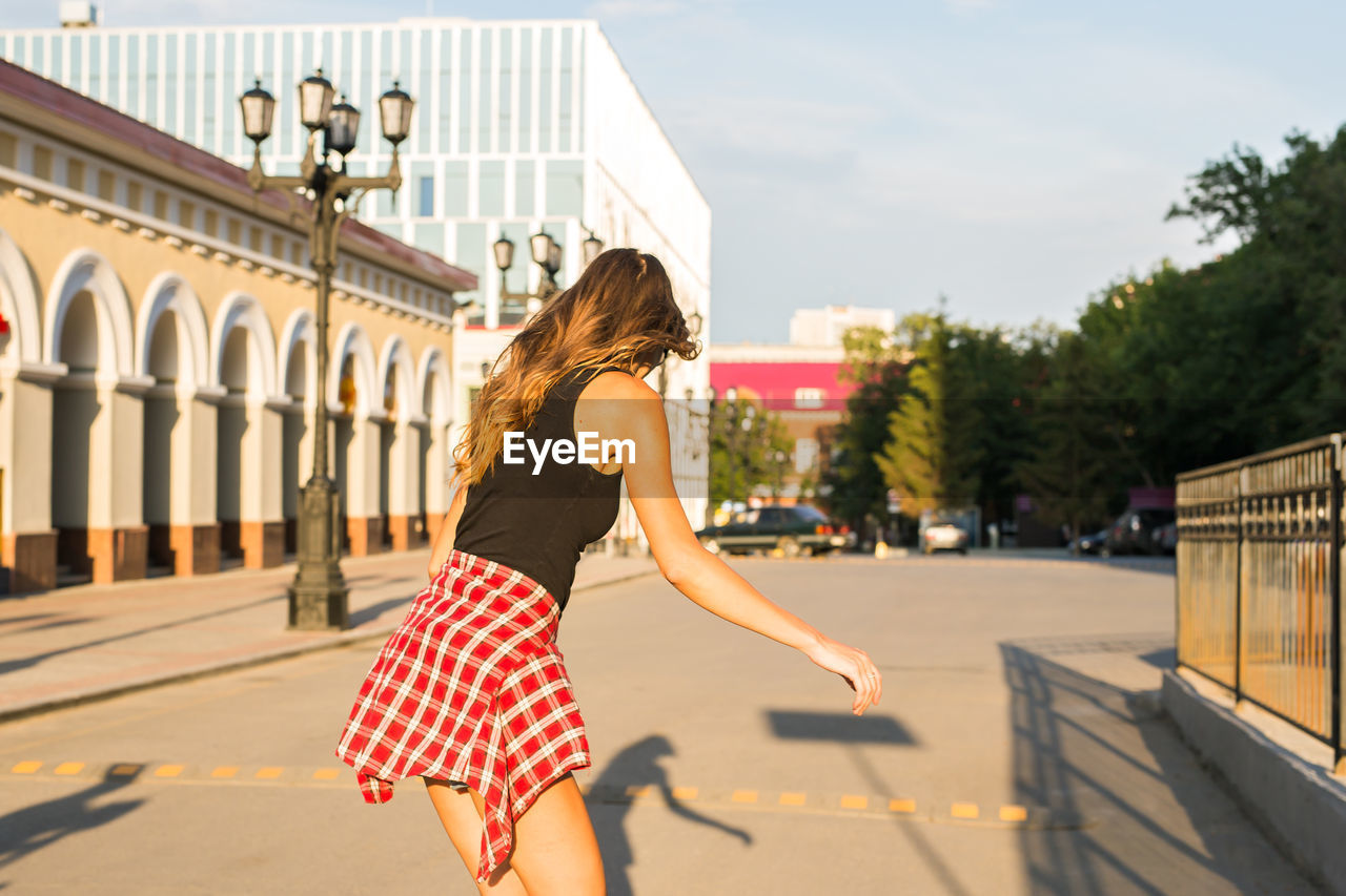 Side view of woman against building in city