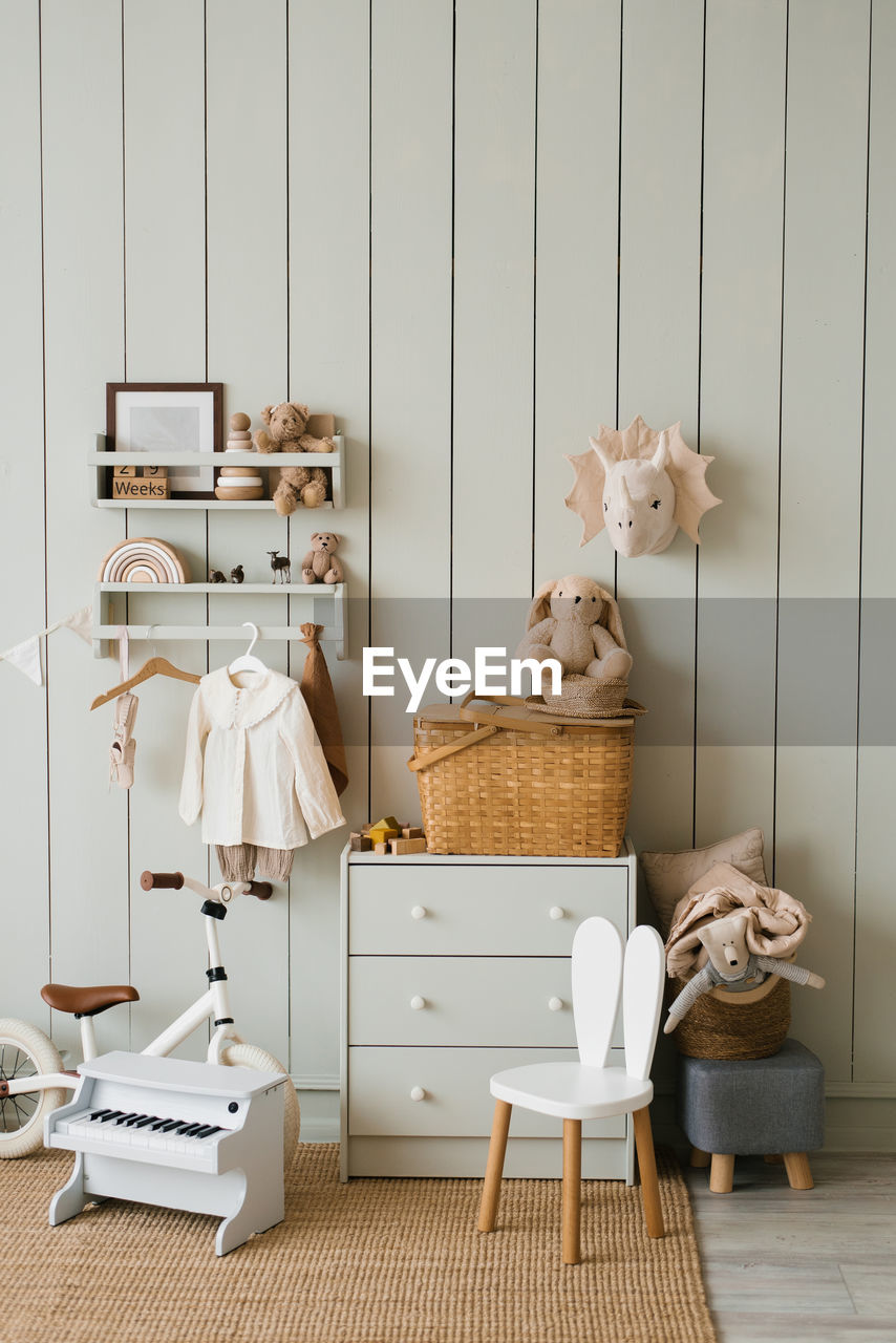 Scandinavian-style children's room, chest of drawers, bicycle, toys, piano toy, armchair and clothes