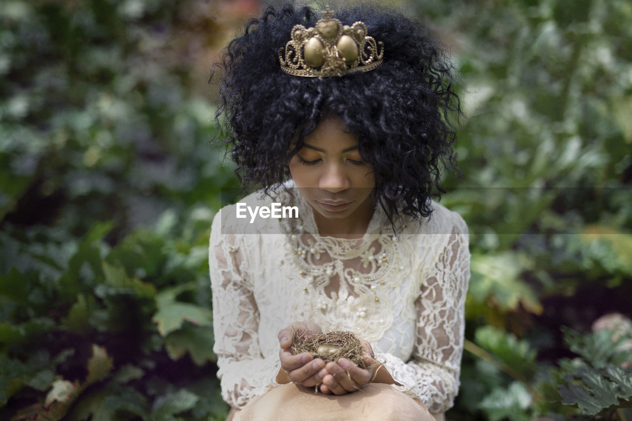 Fantasy portrait of a young woman with a nest in her hands