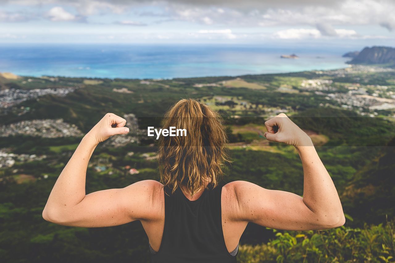 Rear view of woman flexing muscles