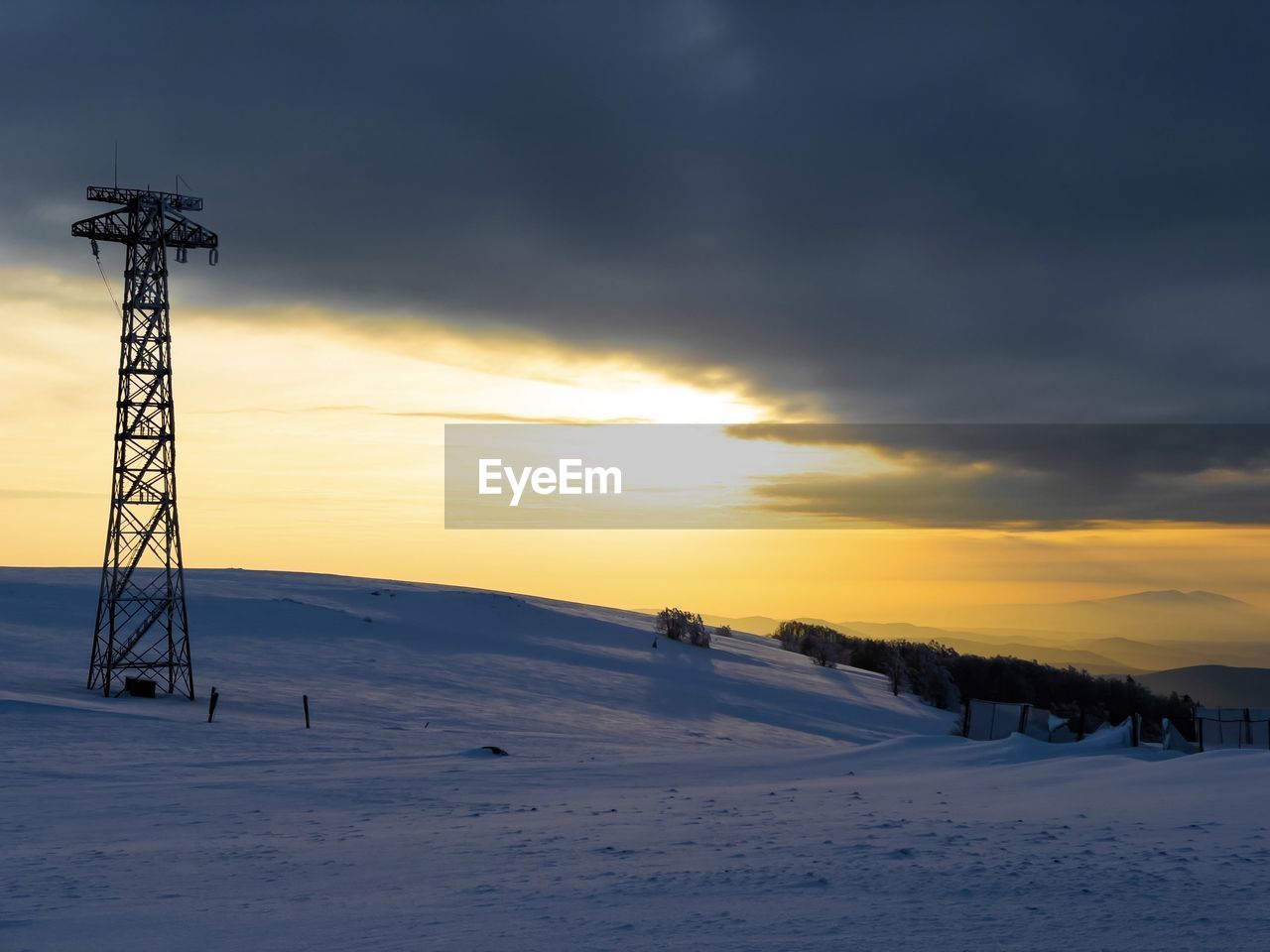 Sunset and dramatic sky in winter over transmission towers