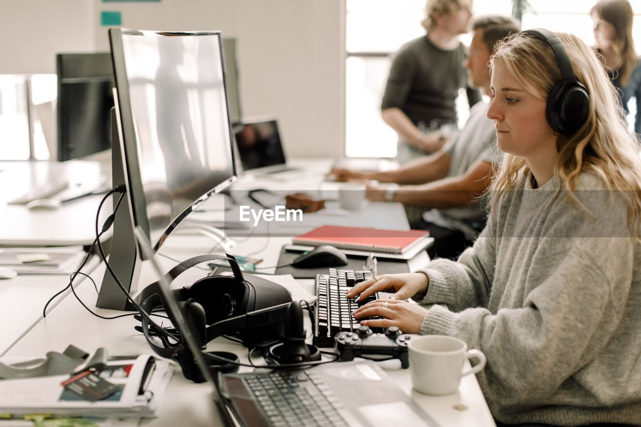 Female colleague working on computer at workplace