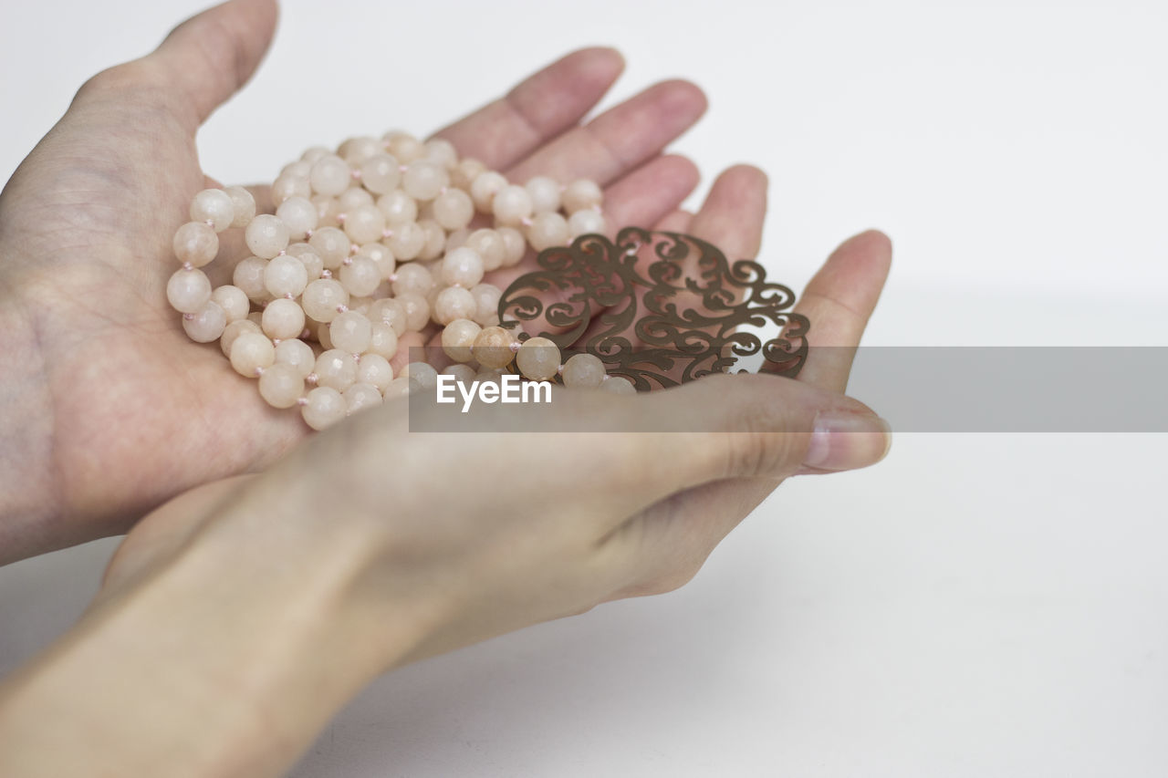 Close-up of hand holding jewelry on table