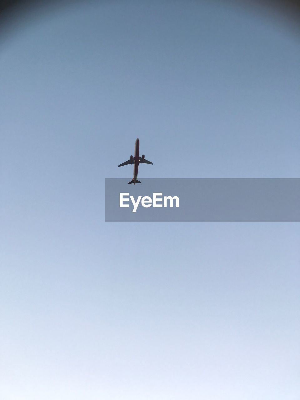 LOW ANGLE VIEW OF AIRPLANE FLYING IN CLEAR SKY