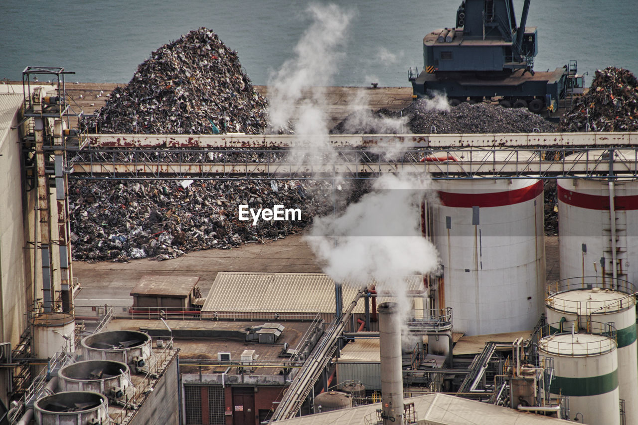 High angle view of smoke emitting from factory at recycling center at harbor, barcelona 