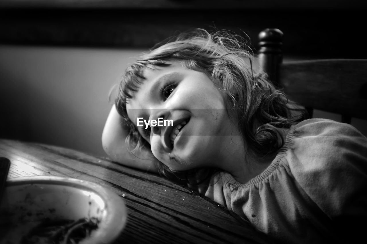 Happy girl leaning on table