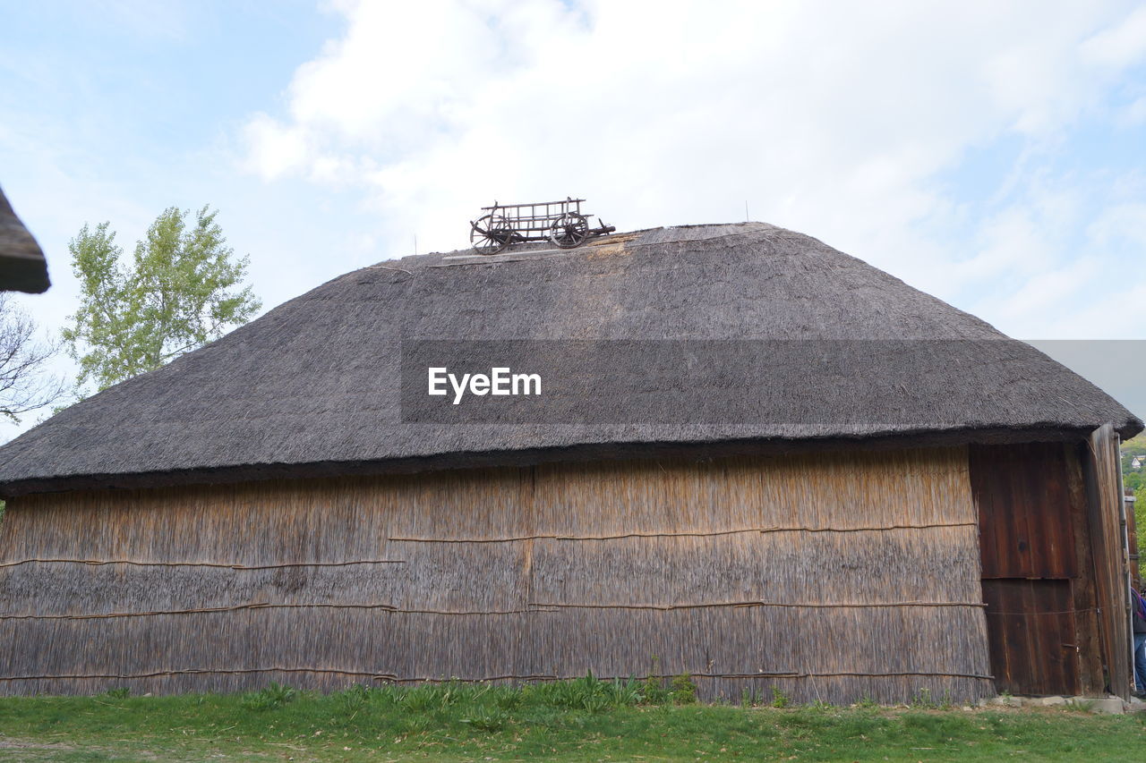 LOW ANGLE VIEW OF HOUSE ON ROOF AGAINST SKY