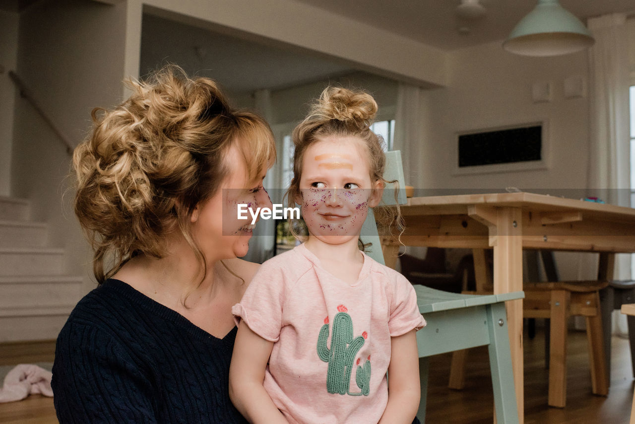 Mother and daughter pulling silly faces whilst playing dress up