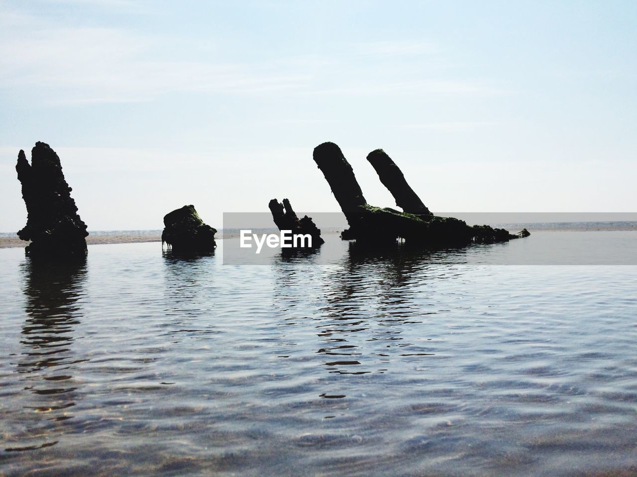 Shipwreck in sea against sky