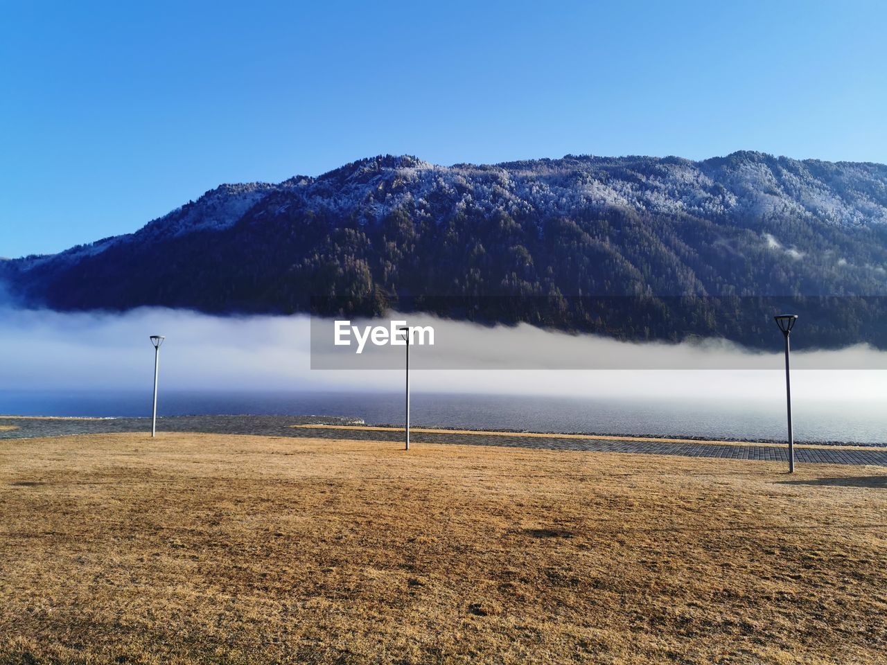 Scenic view of land and mountains against clear blue sky