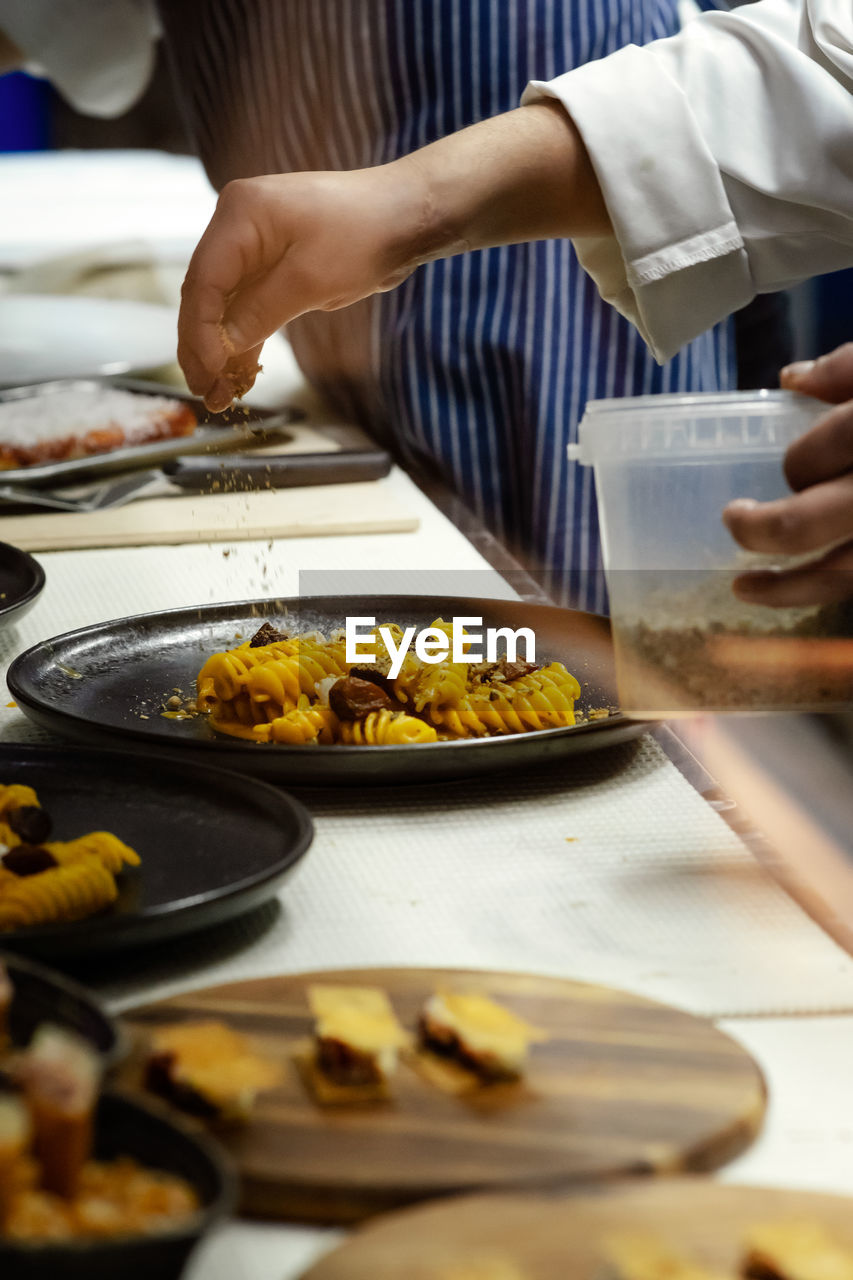 Midsection of chef preparing food on table