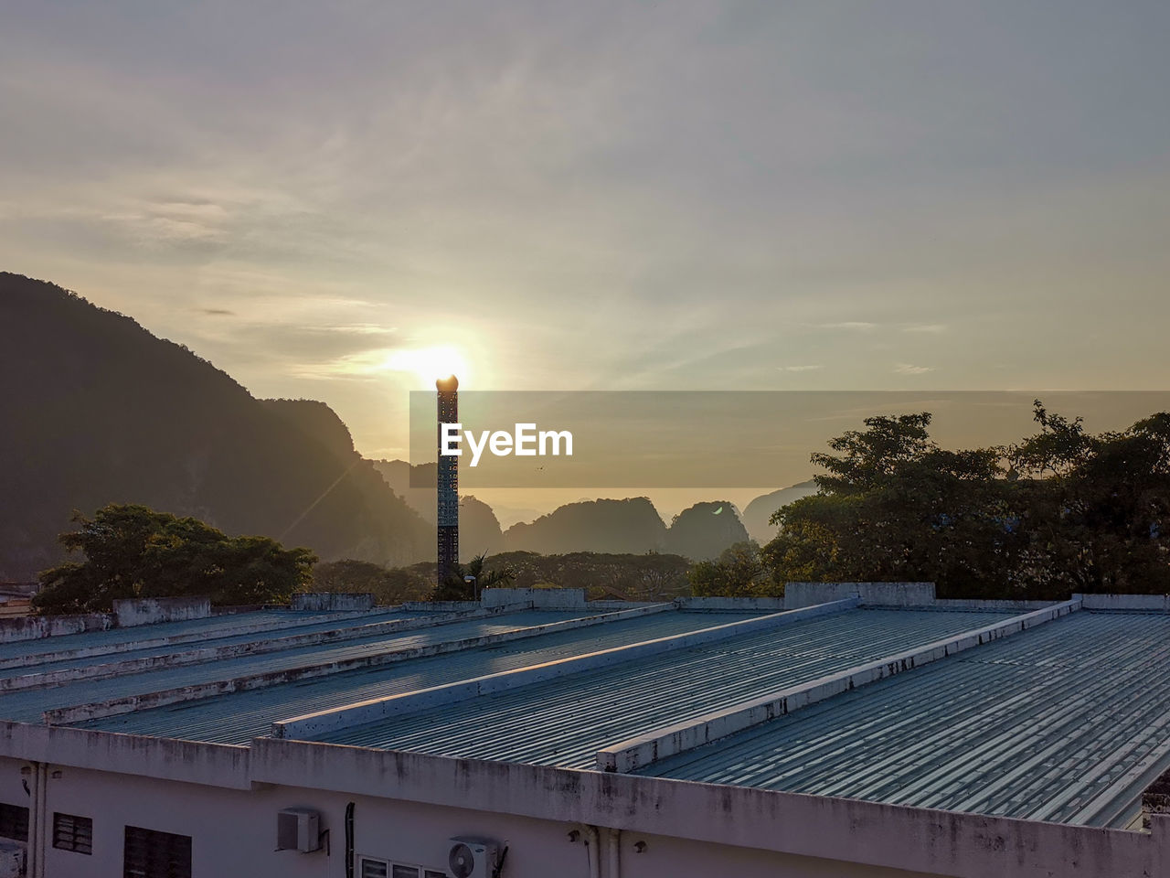 sky, sun, solar energy, solar panel, sunlight, alternative energy, renewable energy, power generation, architecture, environmental conservation, sunset, environment, technology, nature, built structure, industry, finance, cloud, business finance and industry, building exterior, business, economy, outdoors, solar power, evening, mountain, building, environmental issues, roof, construction industry, electricity