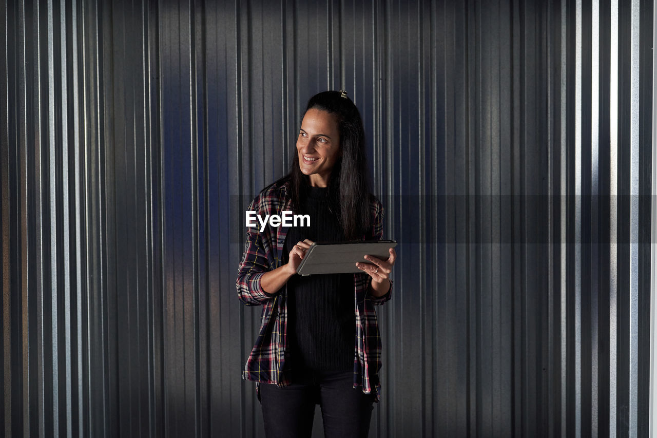 Woman standing at self storage door using tablet